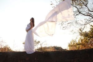 Femme enceinte paisible drapée de blanc. Sans douleur de la grossesse à l'accouchement